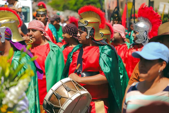 Colorful festival parade in Purísima del Rincón, featuring performers in traditional costumes.