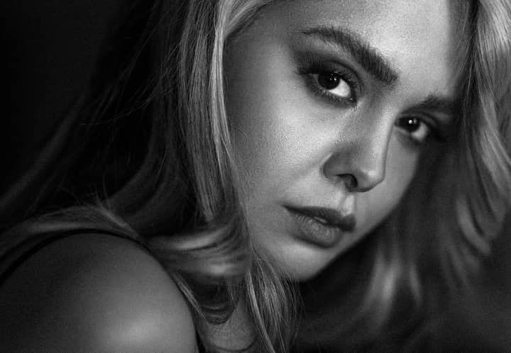 Striking black and white close-up portrait of a woman with long hair and intense gaze.