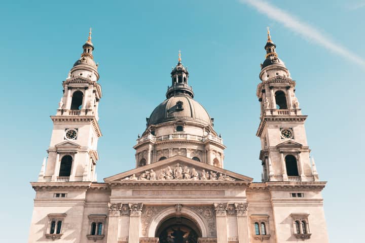 Front view of St. Stephen's Basilica in Budapest with a clear blue sky backdrop.