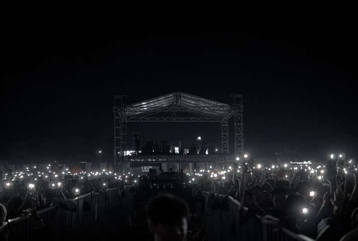 A captivating night concert with a crowd holding phone lights, creating a starry ambiance.