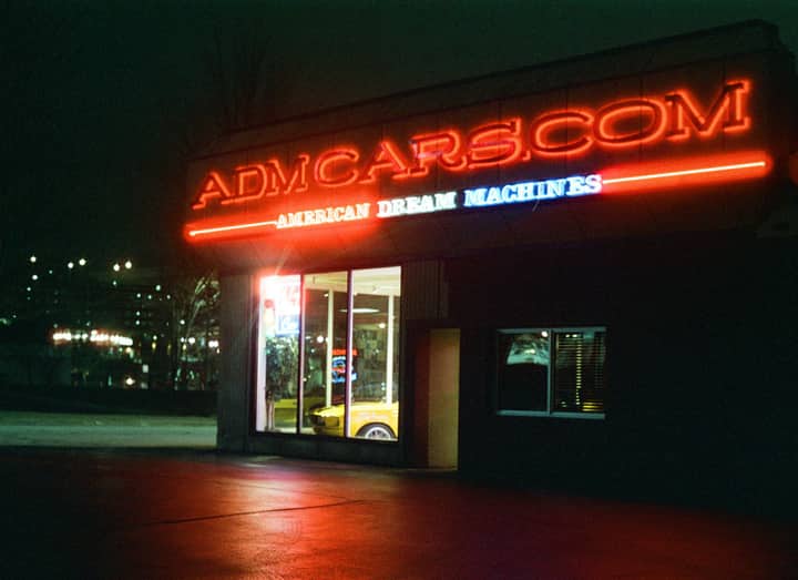 Night view of a neon-lit car dealership in Des Moines, Iowa, USA.