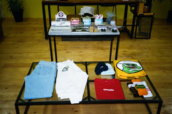 Stylish clothing and accessories displayed on a wooden floor in a modern retail setting.