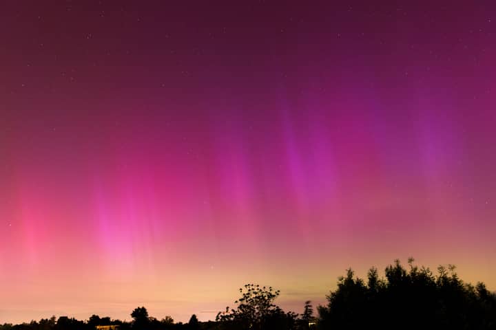 Vibrant aurora borealis illuminates the night sky over Geneva, creating a stunning natural display.