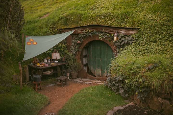 A charming hobbit-inspired house nestled in lush greenery, capturing the essence of rustic countryside living.