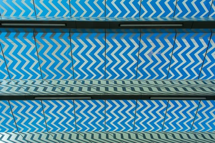 A captivating zigzag pattern in blue on a modern architectural surface, creating a dynamic visual effect.