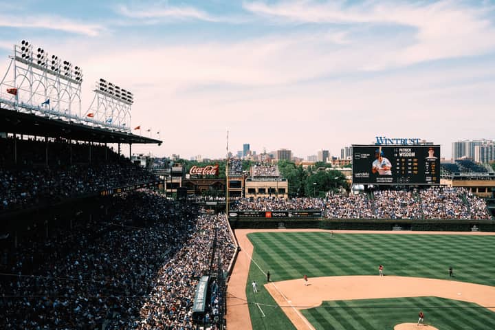Aerial shot of a crowded baseball game at Wrigley Field, showcasing the vibrant cityscape of Chicago.