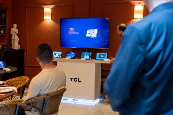 A professional business presentation showcasing new, sleek tablets and technology in a modern showroom setting.