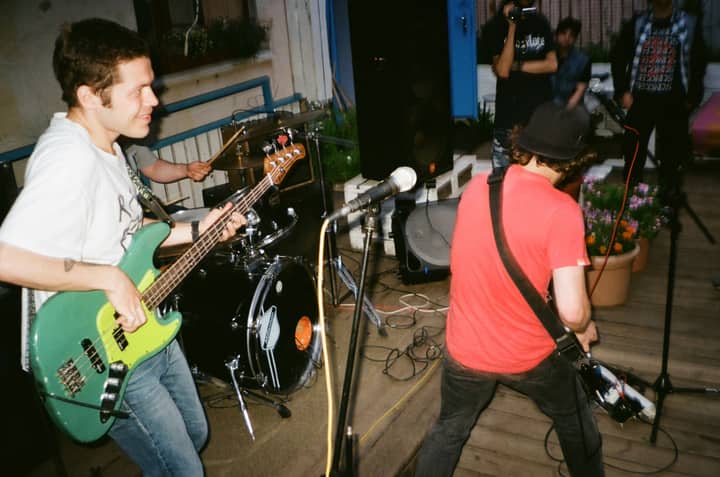 Live indie band performing energetically on an outdoor stage.