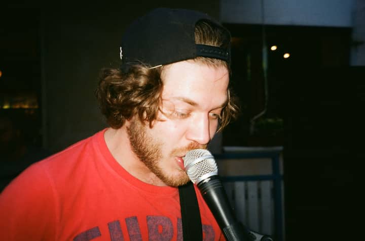 A bearded male singer passionately performing with a microphone.