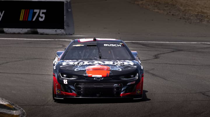 Experience the thrill of a sleek black race car speeding on a professional circuit track.