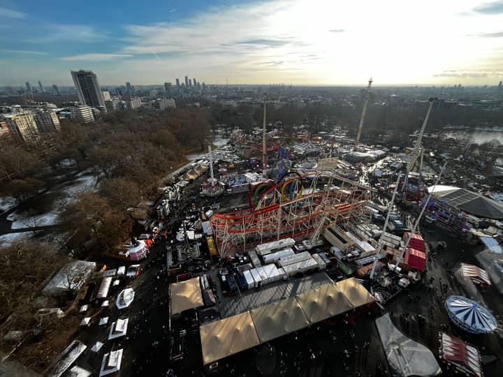 A panoramic aerial shot of Winter Wonderland in Hyde Park with London's skyline in the background.