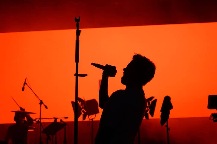 Dramatic silhouette of a singer performing on stage during a live evening concert in Ankara.