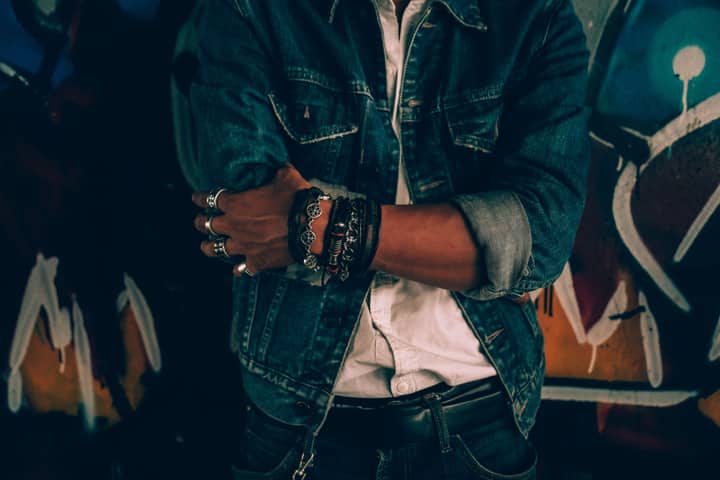 Close-up portrait of an adult in casual denim fashion against graffiti background.