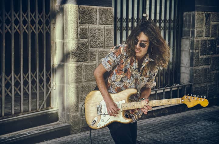 Portrait of a stylish guitarist performing on a city street, capturing urban vibes.