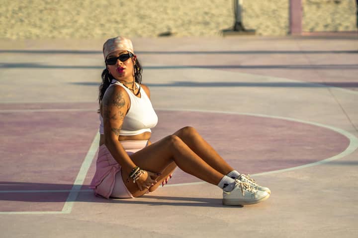 Fashionable woman sitting on a colorful outdoor court in Mexico City, exuding confidence