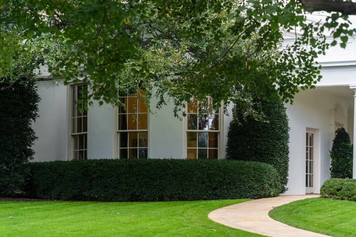 A beautiful suburban house with manicured garden and lush greenery, creating a serene atmosphere.