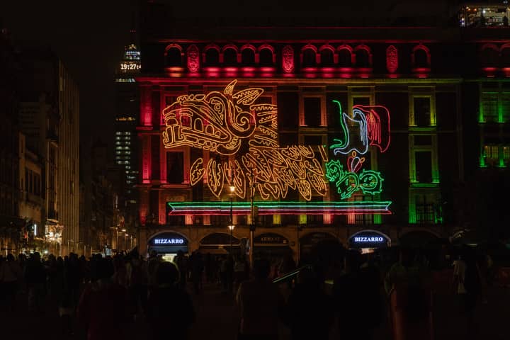 A vibrant neon display celebrating Mexican Independence Day at night in Mexico City.