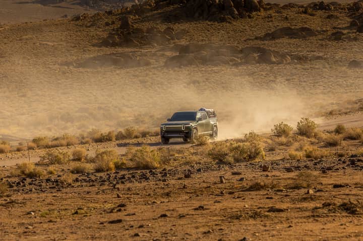 SUV driving through a dusty desert terrain showcasing off-road capabilities and adventure spirit.