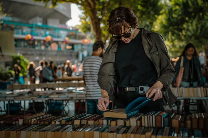 A person explores books at an outdoor market along London's South Bank.