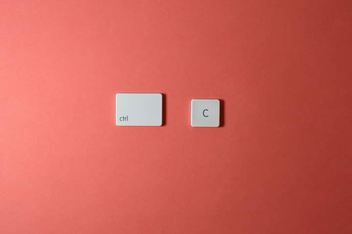 Simple keyboard keys Ctrl and C on a coral background, representing copy function.