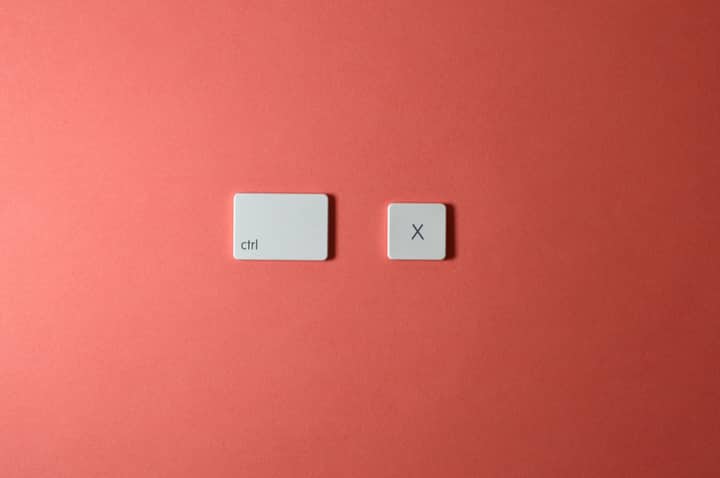 Close-up of ctrl and X keys on a salmon-colored background, perfect for technology themes
