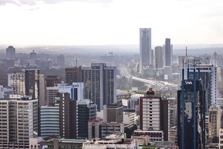 Aerial view of Nairobi's modern skyscrapers and bustling urban landscape under a clear sky.