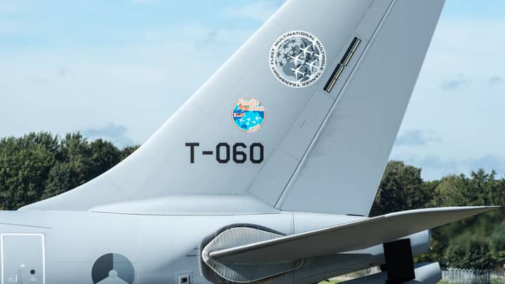 Detailed view of airplane tail with insignia at Hamburg Airport on a clear day.