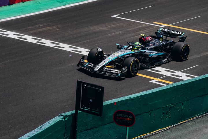 High-speed Formula 1 car crossing the finish line on a race track during the day.