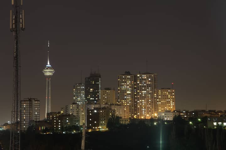 A stunning night view of Tehran's skyline with the iconic Milad Tower prominently visible.