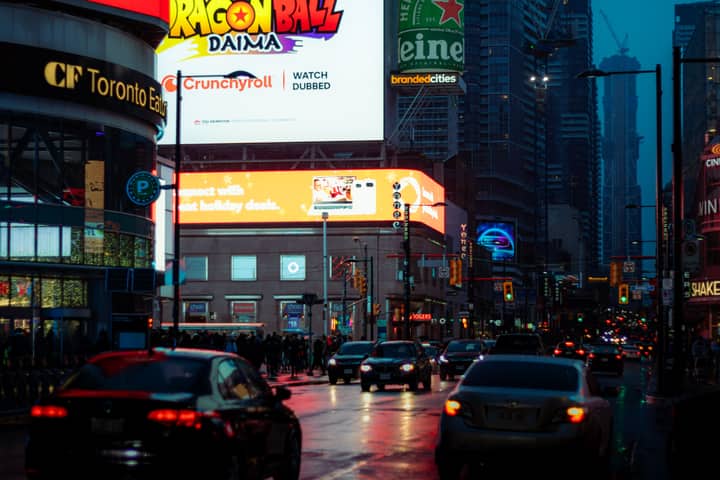 Dynamic city street scene in Toronto with vibrant billboards and bustling traffic.