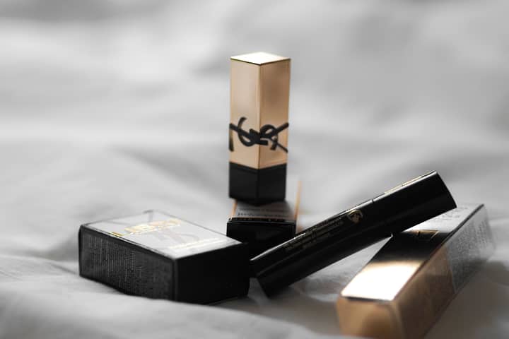 Elegant YSL cosmetics showcased on soft fabric, highlighting luxury beauty products.