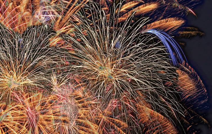 Colorful fireworks burst in the night, creating a dazzling display of light and color.
