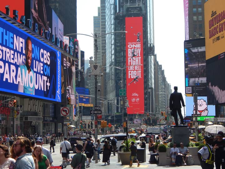 A vibrant scene of Times Square in New York City filled with billboards and crowds of people.