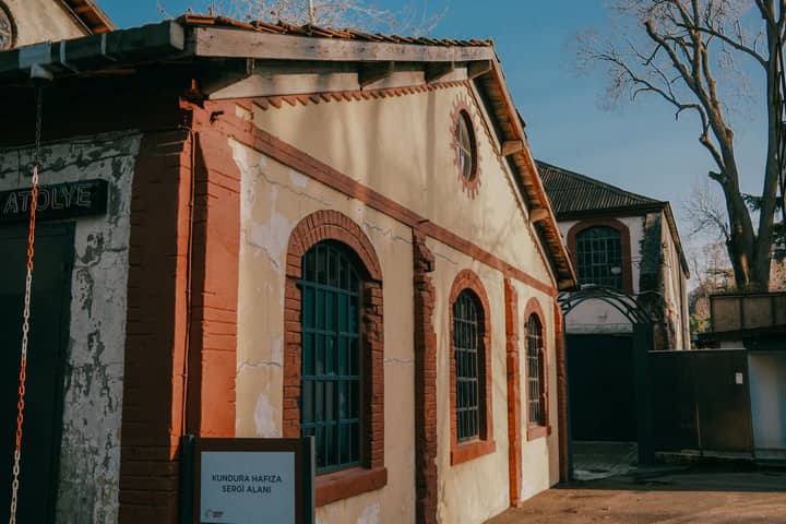 A historic brick building with arched windows under a clear blue sky, showcasing urban architecture.