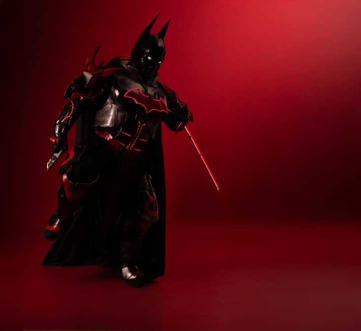 Detailed Batman cosplay in red-black theme, captured with dramatic lighting and mood.