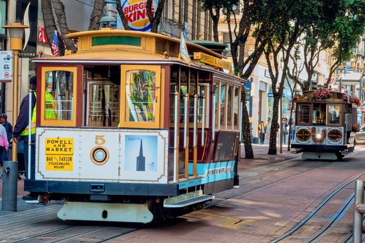 San Francisco cable cars on Market Street, capturing city's charm and vibrant life.