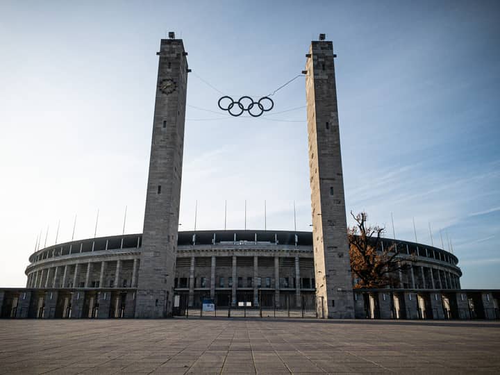 View of the Olympic Stadium in Berlin featuring the Olympic rings between two towers.