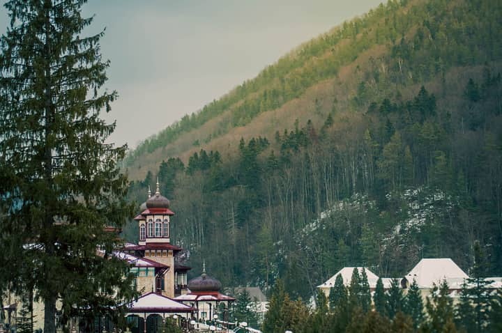 Traditional Romanian building nestled amidst lush forested hills in Romania.