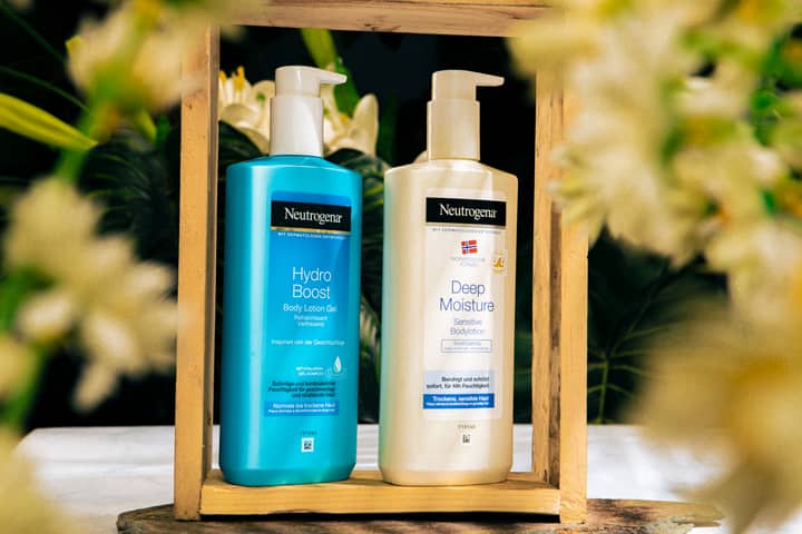 Neutrogena Hydro Boost and Deep Moisture lotions in a floral wooden frame.