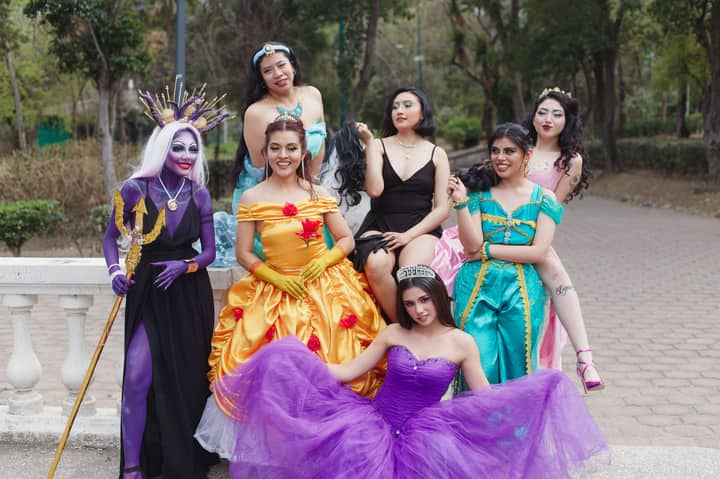 A cheerful group of women in fantasy costumes posing outdoors, exuding vibrant colors and playful energy.