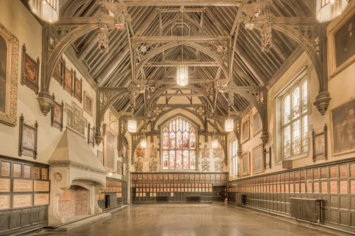 A beautiful historic hall in England featuring ornate timber architecture and stained glass windows.