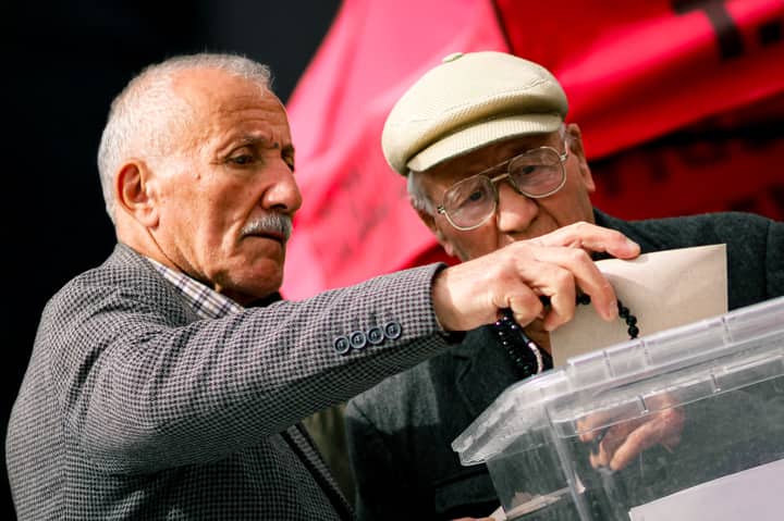 Two senior adults casting their votes at election polls, contributing to democracy.