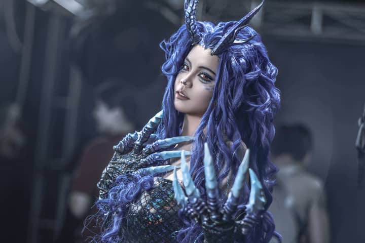 A captivating fantasy cosplay portrait featuring a character with purple hair, horns, and clawed hands, showcasing intricate design and creativity.