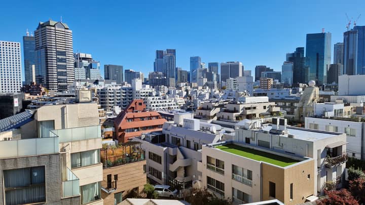 A clear view of Tokyo's modern skyline under a bright blue sky.