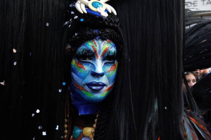 Vibrant portrait of a masked performer in carnival attire, showcasing detailed face paint.