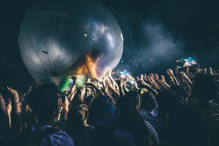 A lively night concert with people interacting with a large zorb ball.