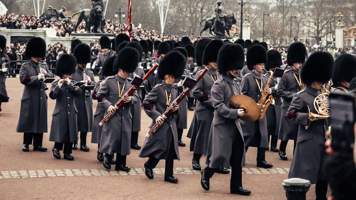 British ceremonial guards marching with musical instruments at Buckingham Palace.