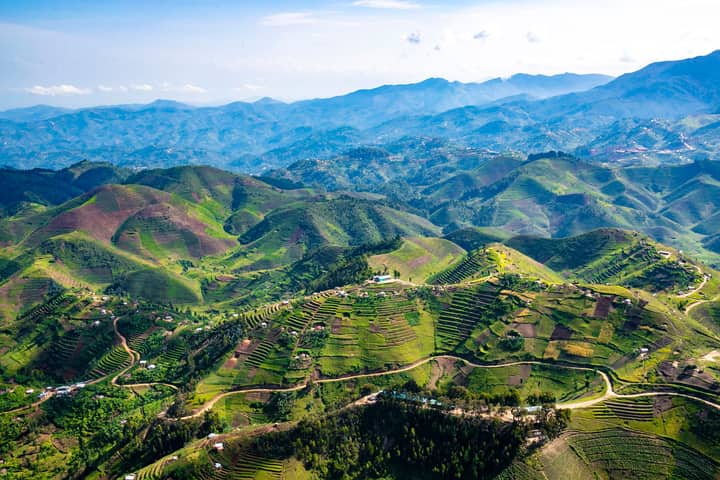 Stunning aerial landscape of vibrant green hills and terraced fields in Rwanda's countryside.