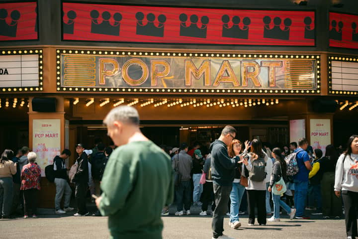 A lively crowd gathers outside the Pop Mart entrance in Taiwan, showcasing vibrant city life and activity.