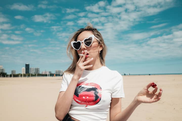 Fashionable woman with heart sunglasses enjoying a sunny day at Montrose Beach.